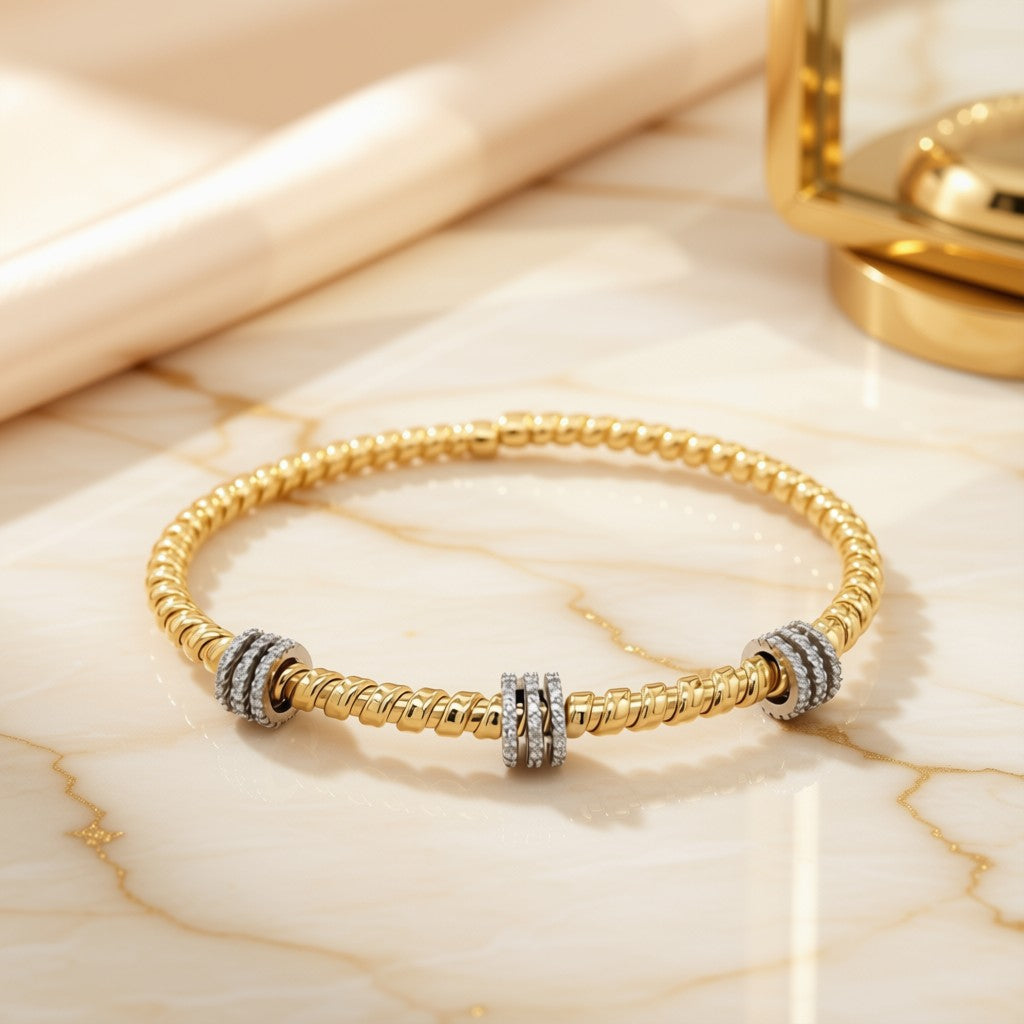 Diamond Rondelle Station Bangle Bracelet in 14K Two-Tone Gold on marble surface